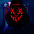 LED Purge Halloween mask glowing red worn by hooded model in the dark